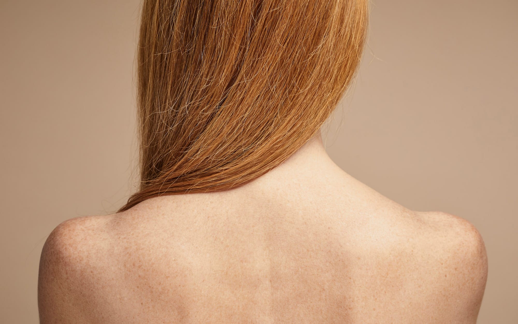Long hair falling across a bare back and shoulders, seen from behind.