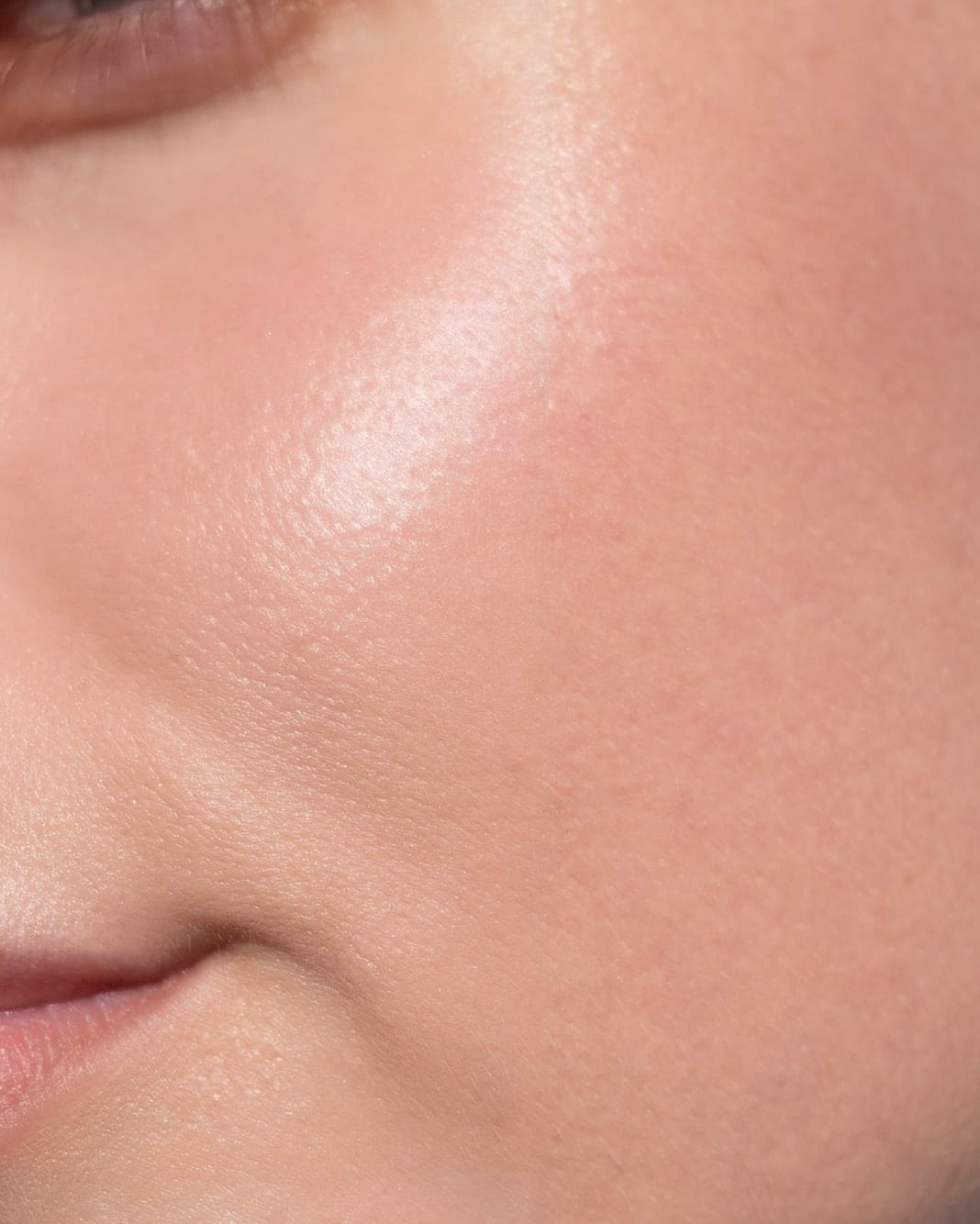A cheek and jawline in close view, skin even and unretouched.