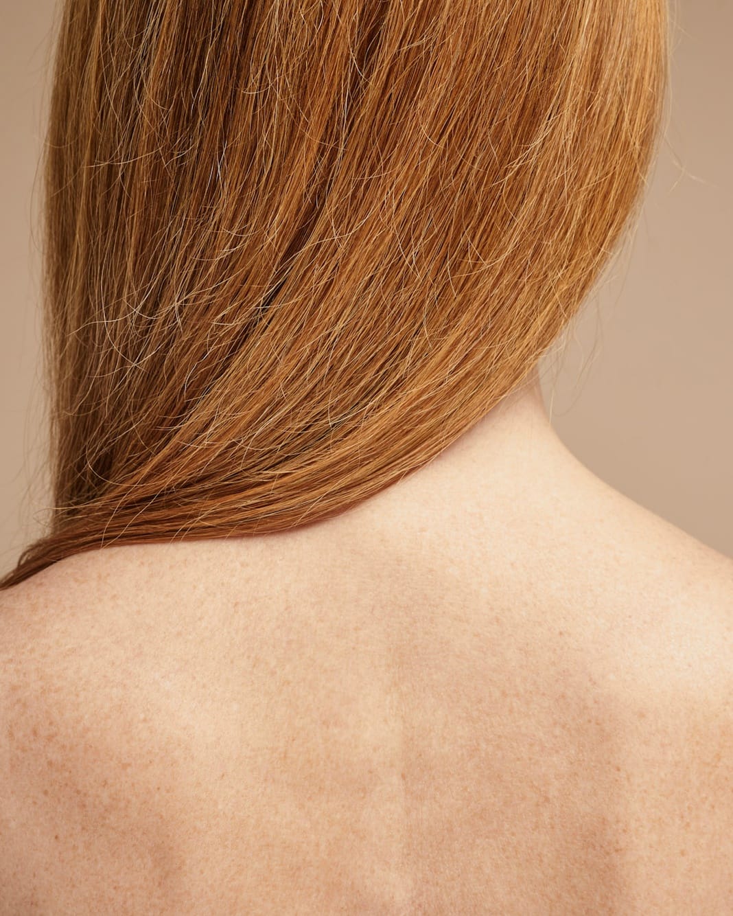 Long hair falling across a bare back and shoulders, seen from behind.