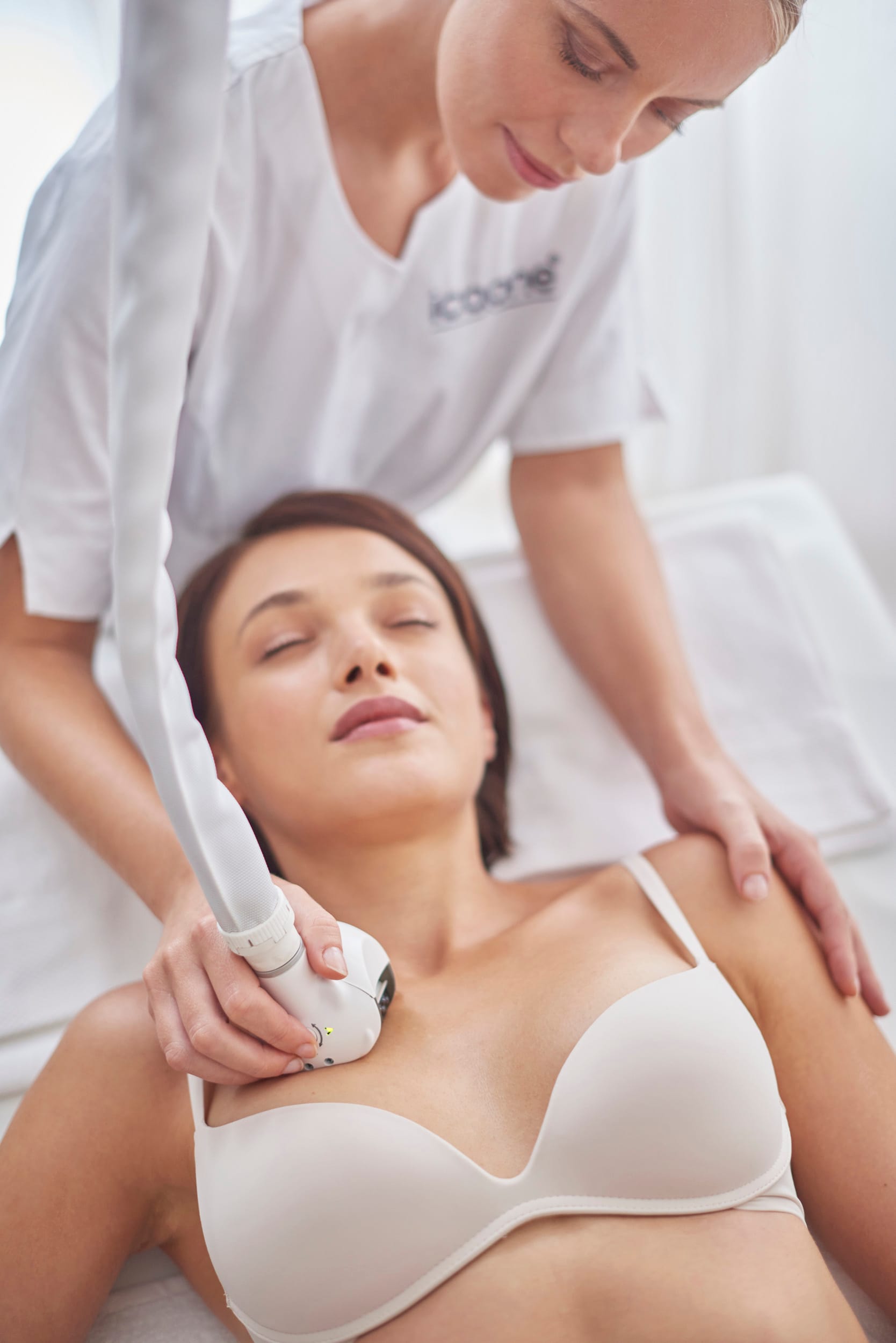 An ICOONE handpiece worked across a client&rsquo;s shoulder and d&eacute;colletage.